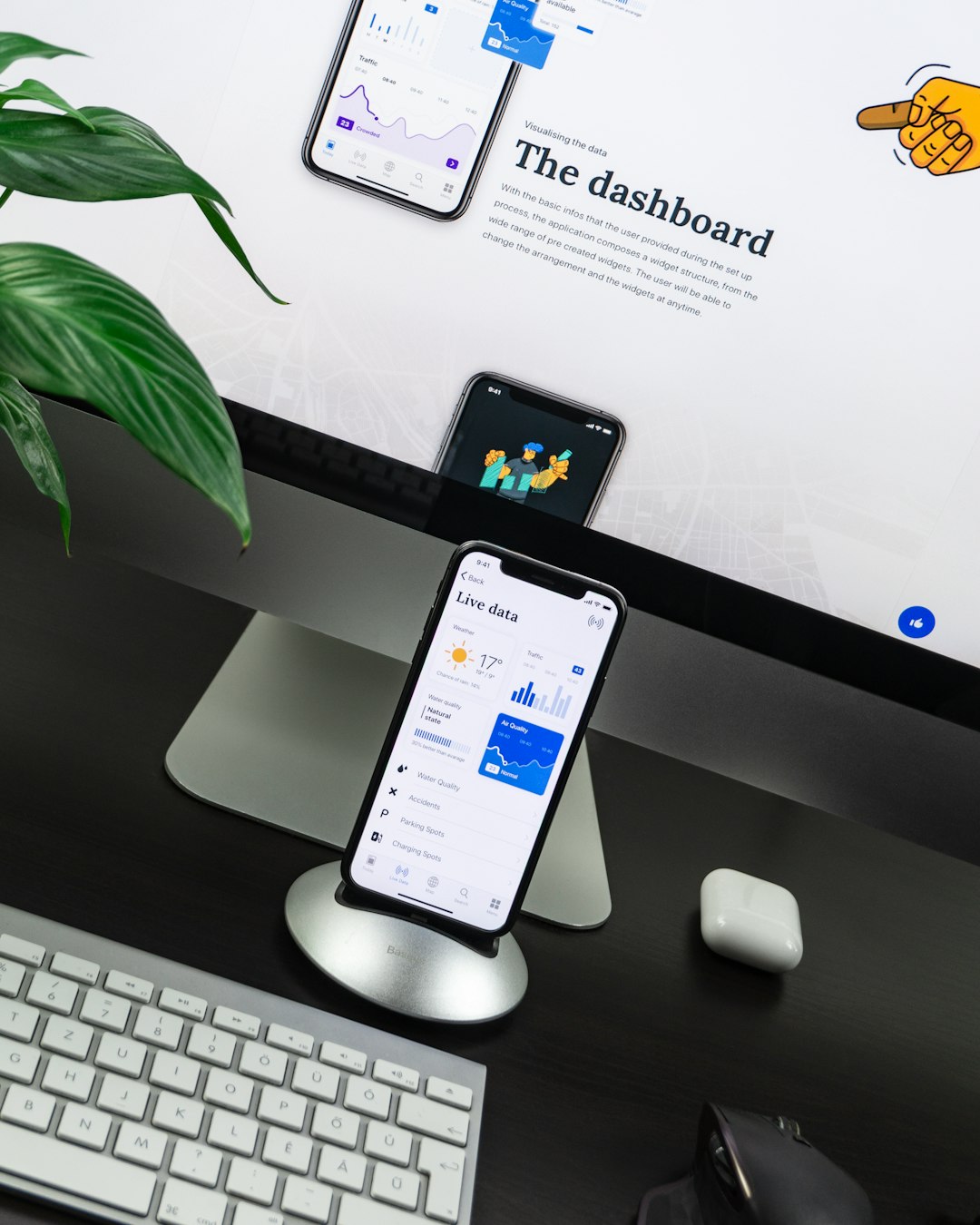 space-gray-iphone-x-on-stand-near-silver-imac-and-apple-magic-keyboard-l0nipfx-ry4